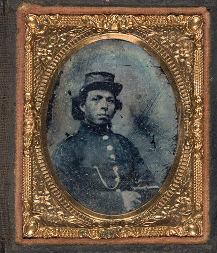 Das Schwarz Weiß Portrait aus dem Jahr 1863 zeigt einen schwarzen Soldaten. r sitzt, hält eine Pistole in der Hand, trägt ein Uhrenband an der Uniformjacke und Hut auf dem Kopf.
